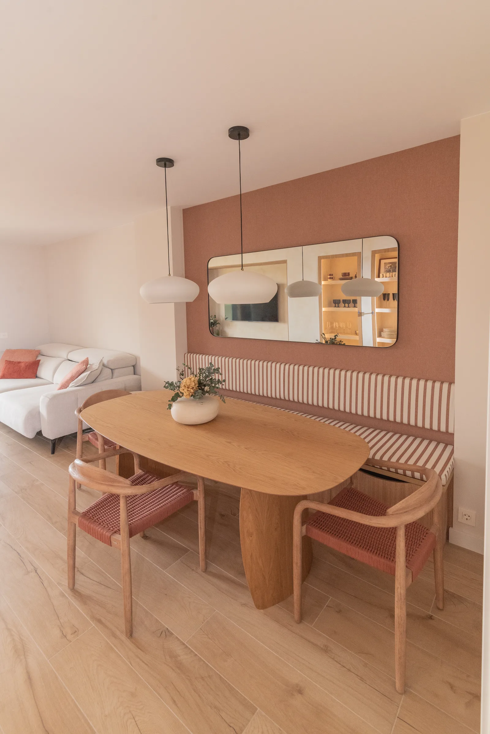 Comedor con pared terracota, mesa de roble orgánica y banco tapizado